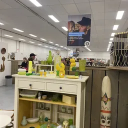 Witte kast met gele en groene huishoudelijke artikelen en decoratieve voorwerpen op de toonbank