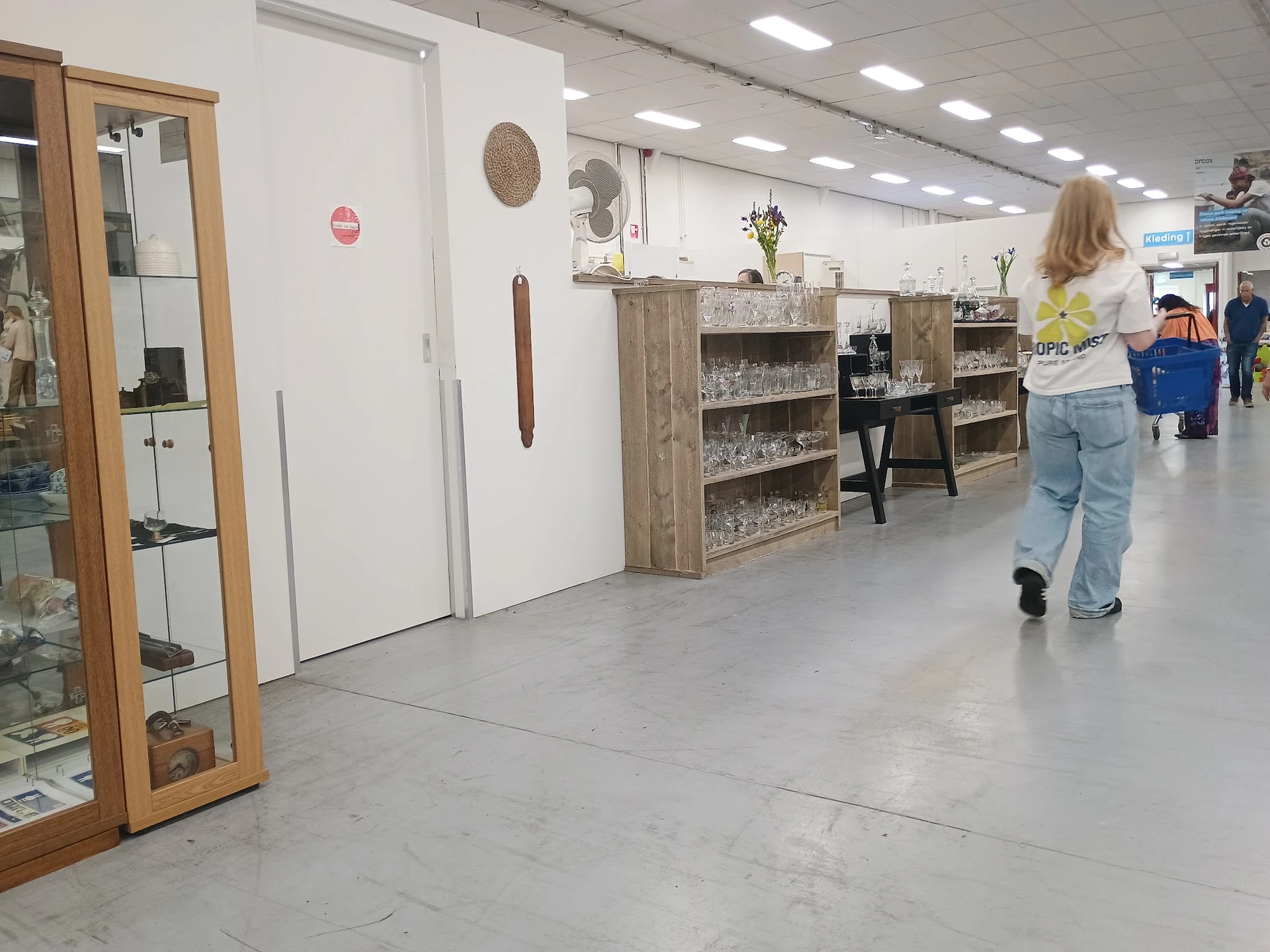 Winkelvloer met houten stellingen, displays en diverse spullen in een kringloopwinkel