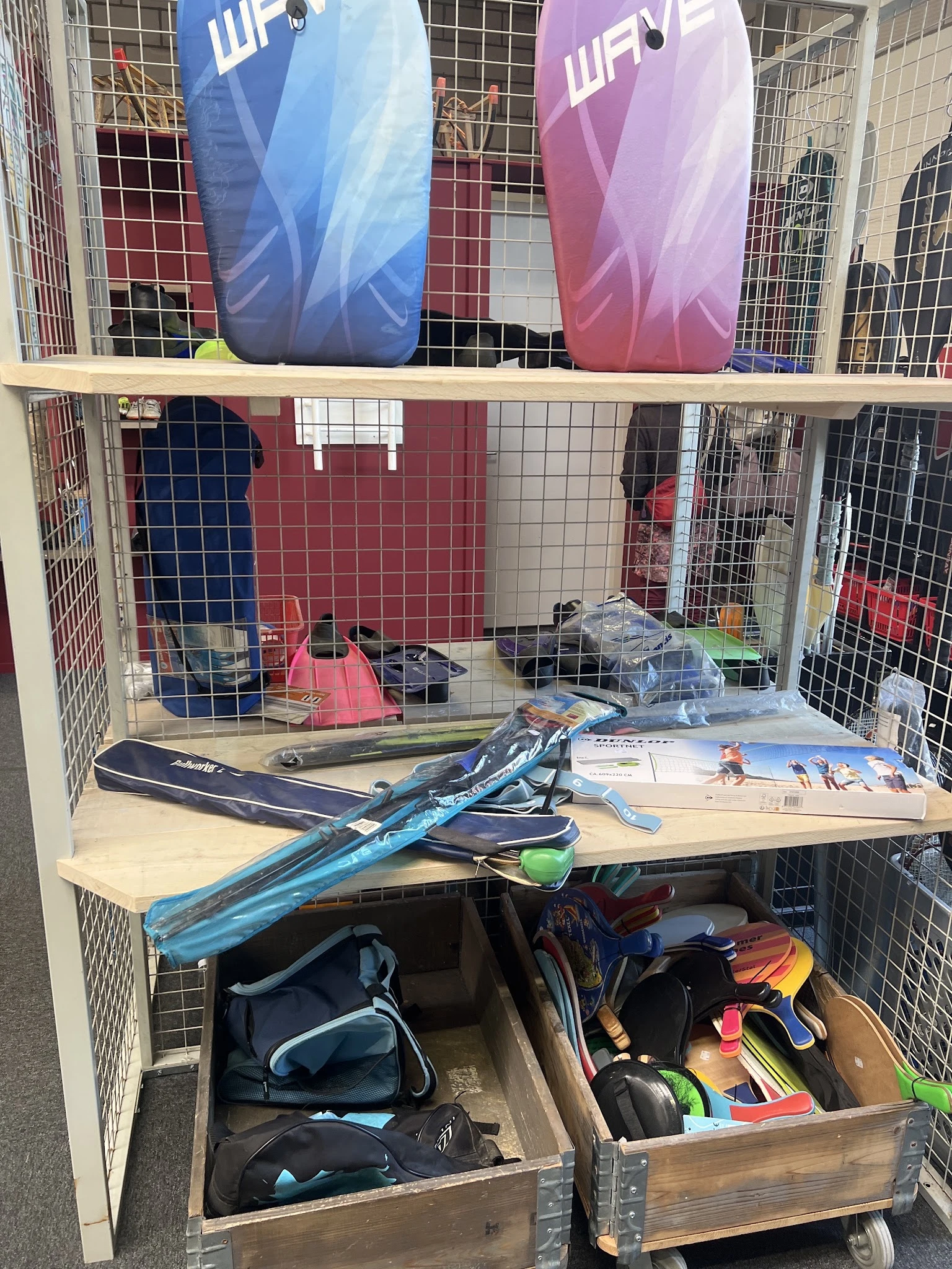 Stellingkast met sportartikelen zoals ski's, snowboards en ander sportmateriaal uitgestald