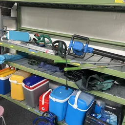 Stellingen met tweedehands spullen zoals tassen, koelboxen en sportartikelen