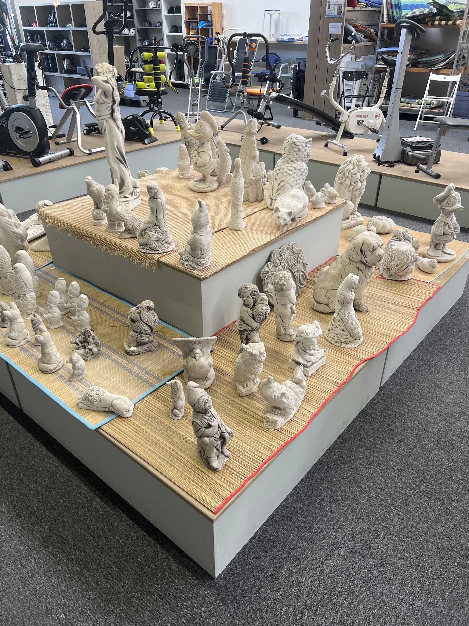 Vitrinekast vol witte keramische beeldjes en decoratieobjecten van dieren en figuren