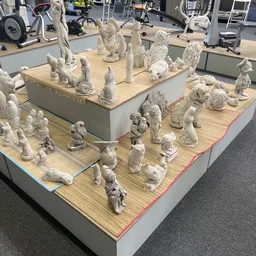 Vitrinekast vol witte keramische beeldjes en decoratieobjecten van dieren en figuren