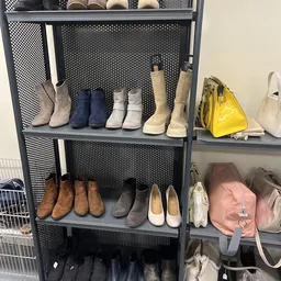 Metalen stellingkast met diverse tweedehands schoenen en laarzen in verschillende kleuren en stijlen