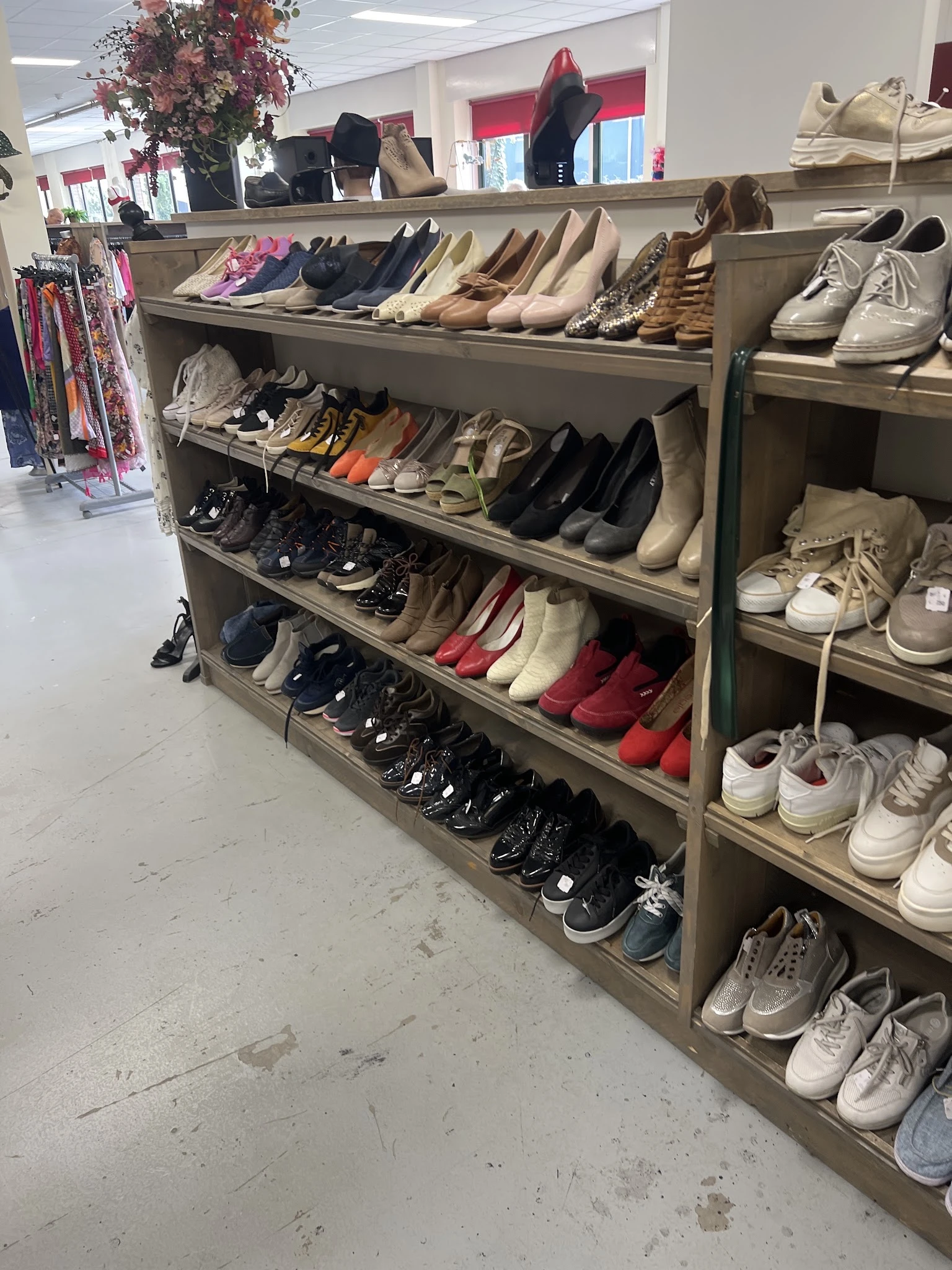 Stellingen met uitgestalde tweedehands schoenen in verschillende kleuren en stijlen