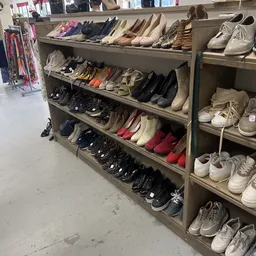 Stellingen met uitgestalde tweedehands schoenen in verschillende kleuren en stijlen