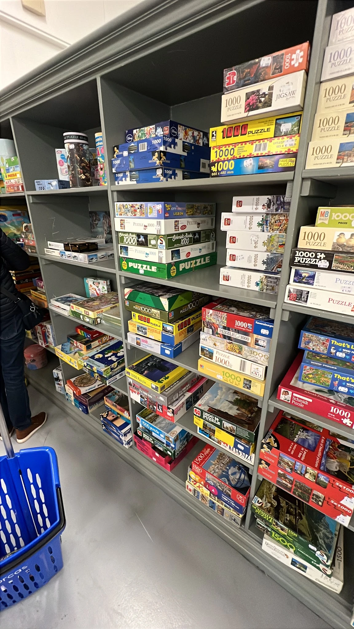Volle stellingen met puzzels en bordspellen in verschillende kleuren en merken