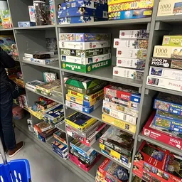 Volle stellingen met puzzels en bordspellen in verschillende kleuren en merken