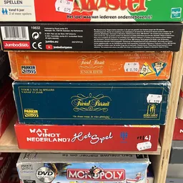 Stapel vintage bordspellen in dozen, waaronder Trivial Pursuit edities en 'Wat Vindt Nederland'-spel