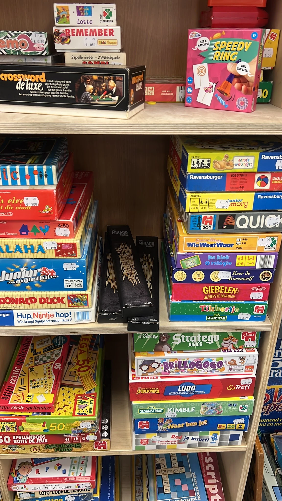 Rekken met tweedehands bordspellen en kinderspellen in de winkel