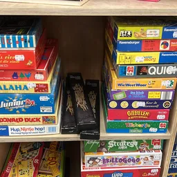 Rekken met tweedehands bordspellen en kinderspellen in de winkel