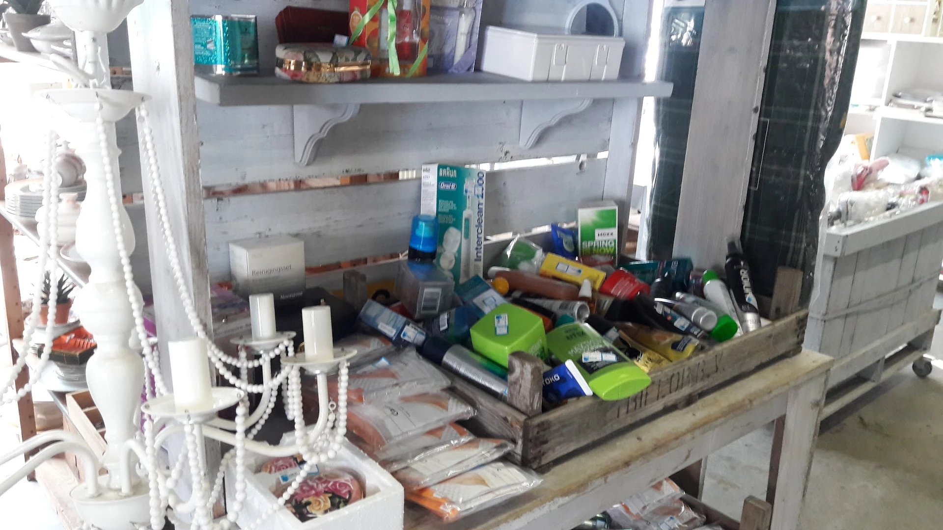 Stellage met verschillende doos- en plastic verpakkingen, spullen en huishoudartikelen, rommelig opgestapeld