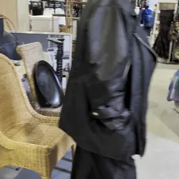 Tweedehands kleding op rekken, waaronder een gele trui en zwarte jas