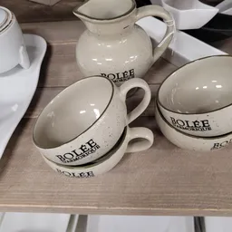 Close-up van drie witte serviesgoed-items met 'BOLEE' branding en decoratieve rand