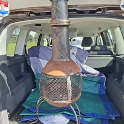 Terracotta tuinkachel of chiminea in laadruimte van auto