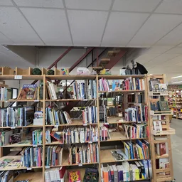 Houten boekenkasten met dvd's, blu-rays en boeken netjes uitgestald in de winkel