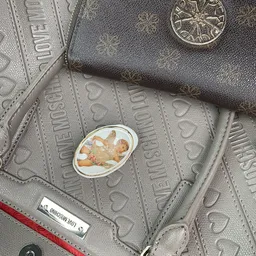 Close-up van een decoratief bordje met afbeelding van een kreeft op tweedehands tassen