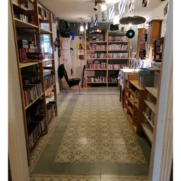 Kringloopwinkel-interieur met boekenrekken langs beide zijden en een leeshoek met stoel in het midden