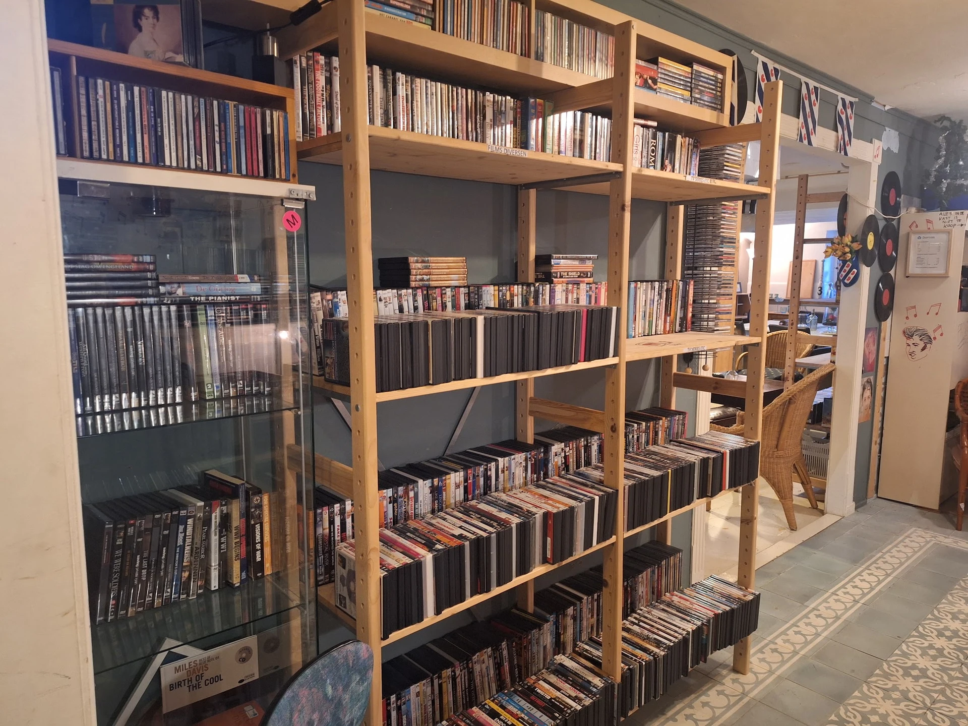 Houten boekenkast met honderden cd's en dvd's netjes uitgestald op meerdere planken