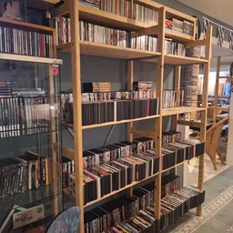 Houten boekenkast met honderden cd's en dvd's netjes uitgestald op meerdere planken