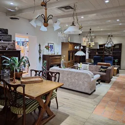 Winkelvloer met meubels, tafels, stoelen, lampen en kasten in een kringloopwinkel