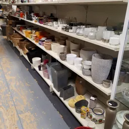 Stellingen met huishoudwaar: potten, bakjes, serviesgoed en decoratieve items