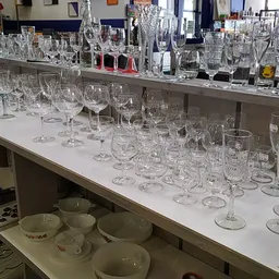 Uitgestalde kristallen glazen en drinkglazen op winkelrekken en tafels