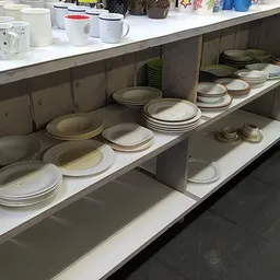 Stellingen met servies en borden in verschillende maten en kleuren, netjes uitgestald