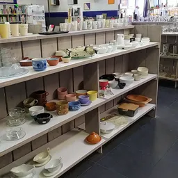 Vitrinekasten met servies, glazen, kommen en ander huishoudelijk goederen uitgestald op meerdere niveaus