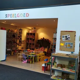 Kinderspeelhoek met kleurrijke houten stoeltjes, tafels en speelgoed in een kringloopwinkel