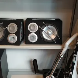 Twee zwarte dozen met keukenzeefjes en andere keukenartikelen op een witte plank