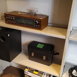 Stellingkast met vintage elektronicaapparatuur en audio-items uitgestald