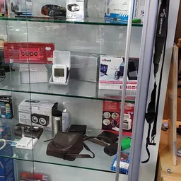 Glazen vitrinekast met elektronica en apparaten zoals speakers, draadloze apparaten en accessoires uitgestald