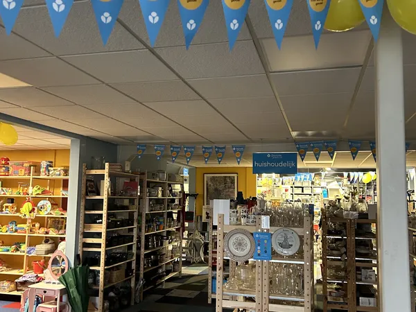 Overzicht van kringloopwinkelinterieur met stellingen, winkelrekken en huishoudelijke artikelen