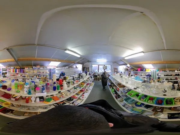 360-graden panoramafoto van het interieur van een kringloopwinkel met stellingen vol spullen