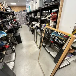 Winkelinterieur met stellingen, dozen en spullen, betonnen vloer, rommelig magazijnachtig uiterlijk
