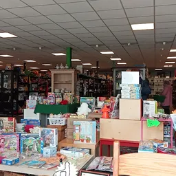 Binnenaanzicht van kringloopwinkel met stellingen, toonbanken vol boeken, speelgoed en diversen huishoudartikelen