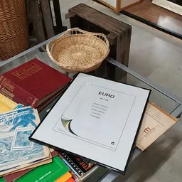 Tafel met tweedehands boeken, een geweven mand en een EURO-publicatie tussen andere spullen