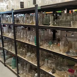 Glazen kasten vol met diverse glazen, kristal en glaswerk in verschillende vormen en maten