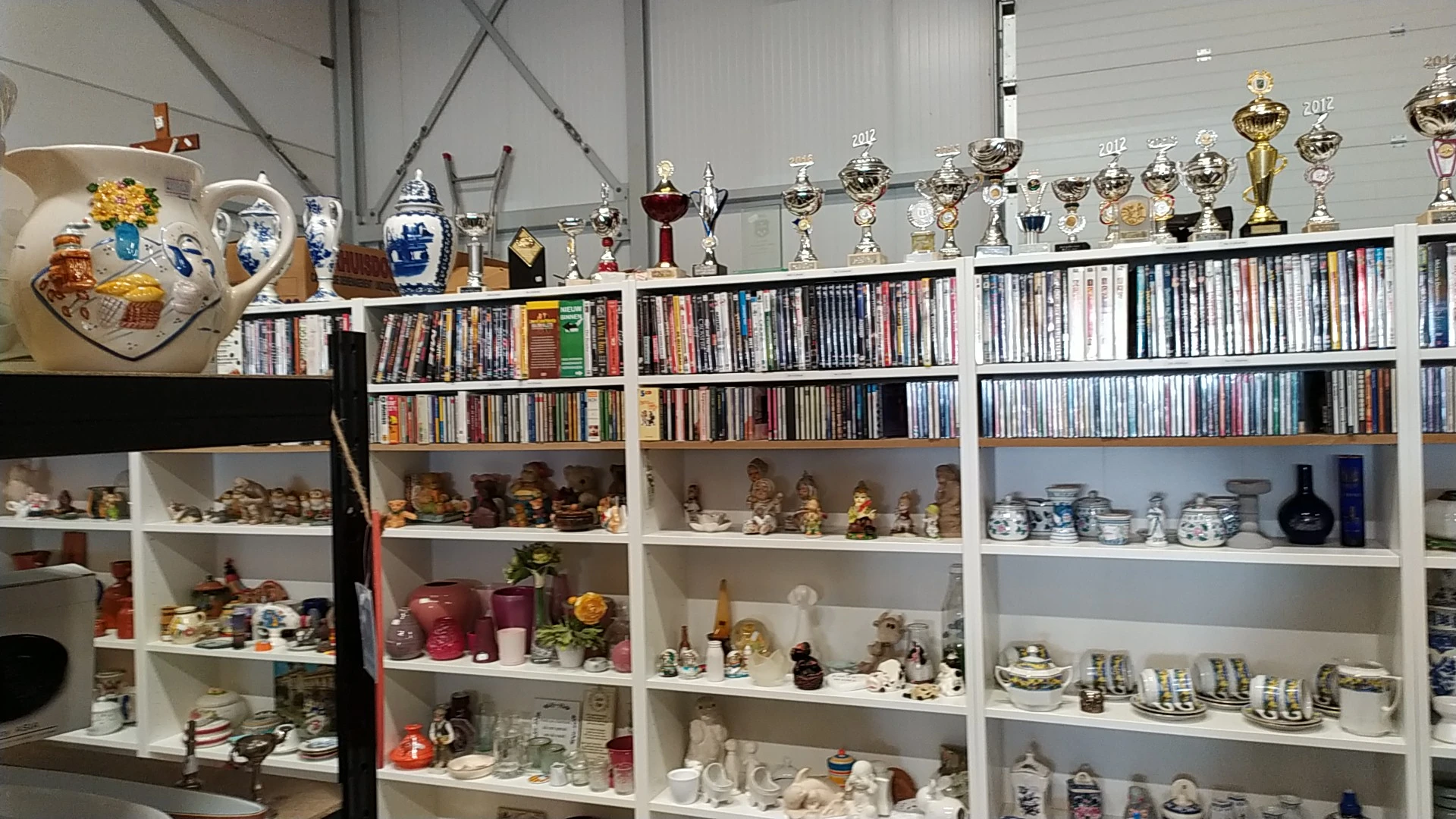 Winkelstellingen met cd's, boeken, trofeeën, serviesgoed en decoratieve items