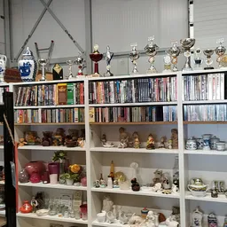 Winkelstellingen met cd's, boeken, trofeeën, serviesgoed en decoratieve items