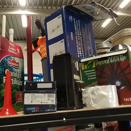 Stellage met diverse gebruikte artikelen zoals dozen, elektronica en huishoudspullen