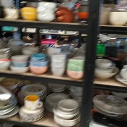 Stellingen met diverse serviesgoed, borden, schalen en bakjes in verschillende kleuren en maten
