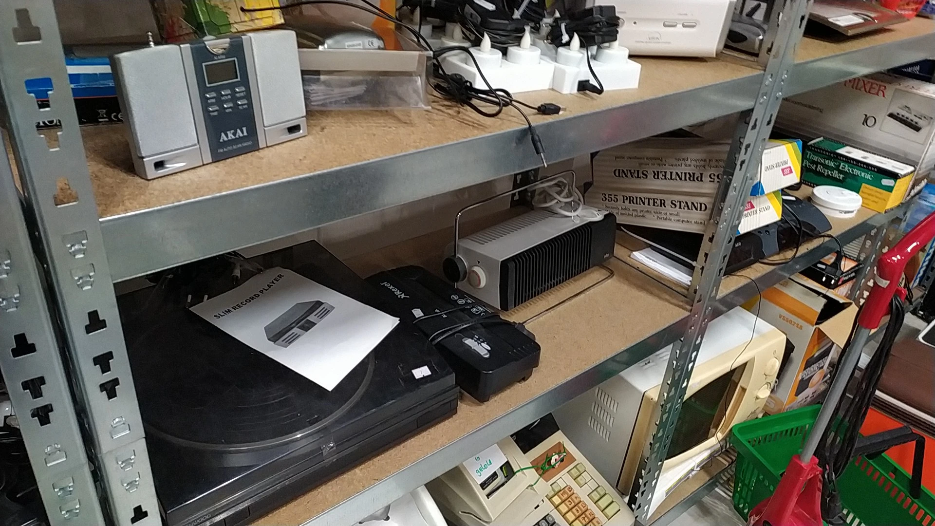 Tweedehands elektronica op een tafel, waaronder een platenspeler, versterker en ander audiotuig