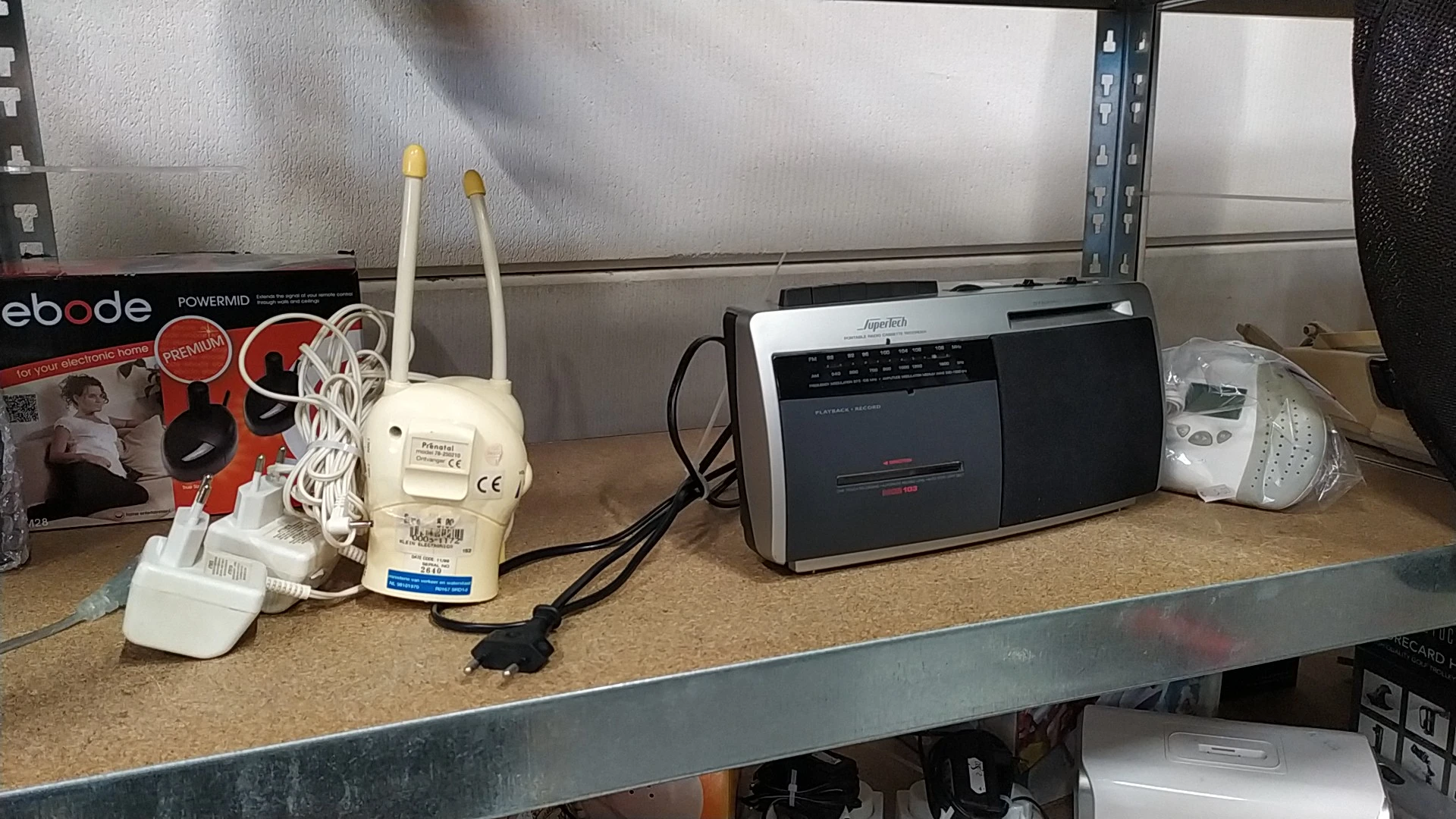 Tweedehands elektronica op een werkblad: wifi-router, cassettespeler en andere elektronische apparaten
