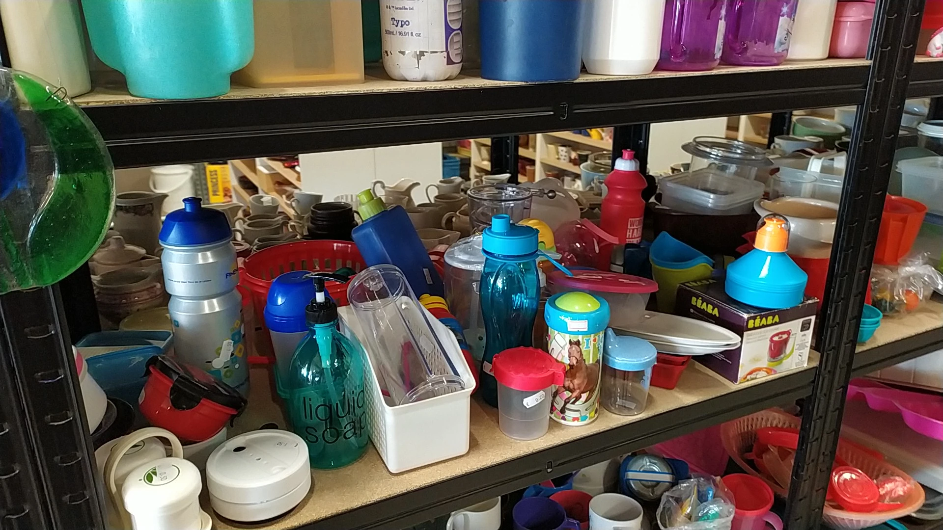 Verschillende huishoudelijke items en containers op een plank in een kringloopwinkel