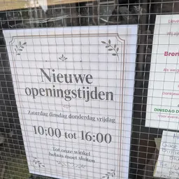 Papieren winkelkaart met openingstijden en decoratieve elementen