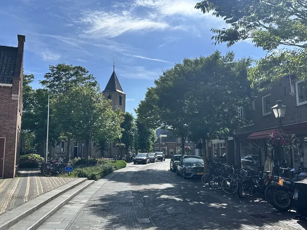 Dorpsstraat in Nootdorp met kerkgebouw en winkelpanden aan beide zijden