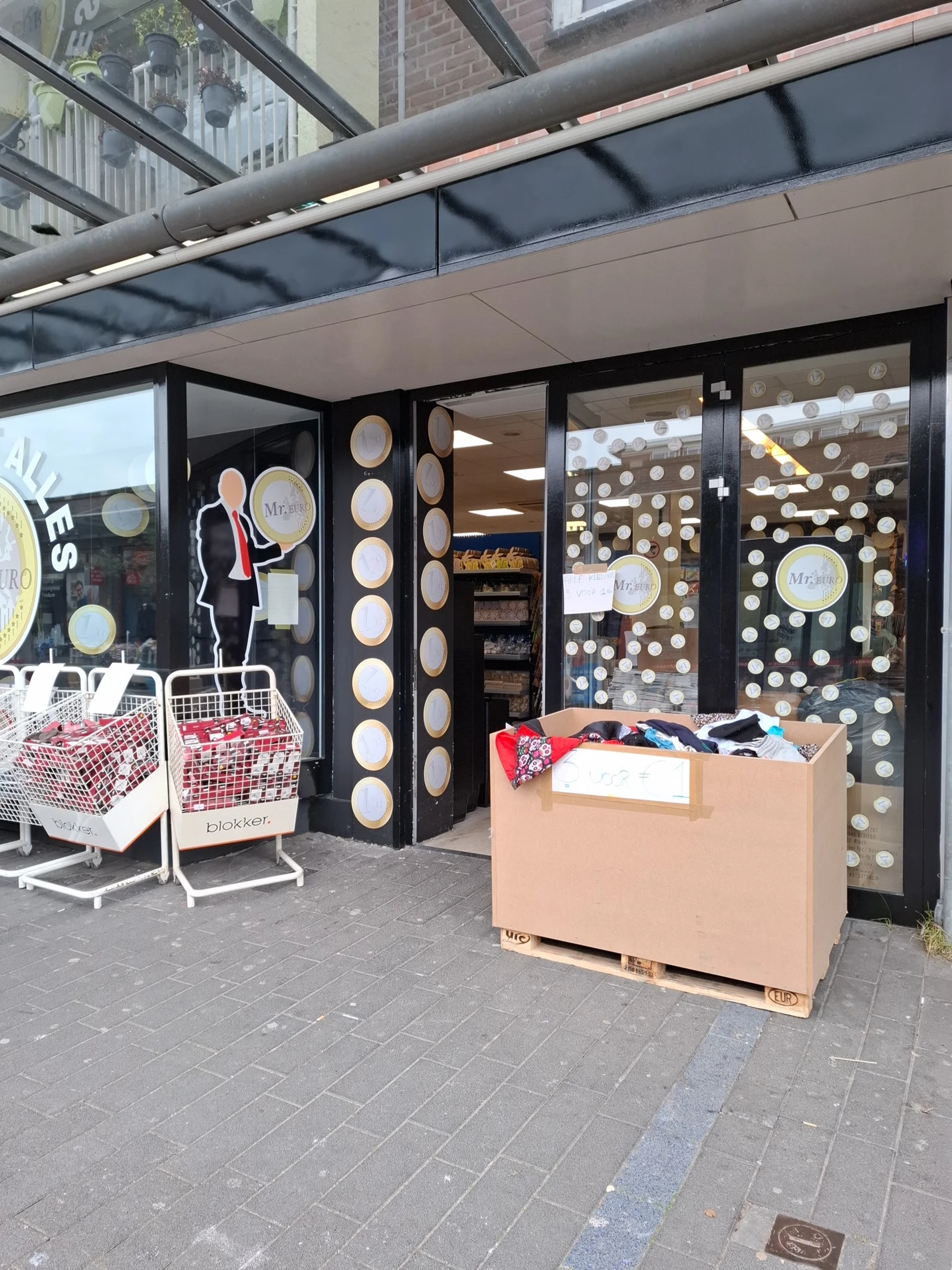 Winkelruit met decoratieve borden en etalage met kleding en dozen op straat