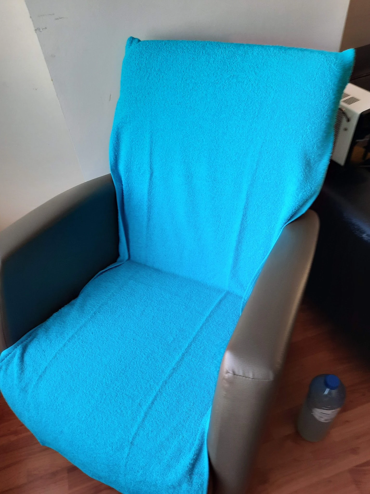 Close-up van een blauwe stoelzitting en rugleuning met zwarte armleuning