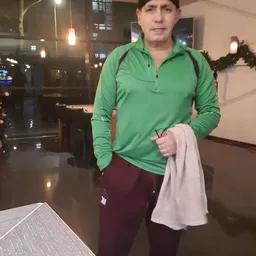 Persoon in groen sportshirt en bordeauxrode broek in winkelinterieur